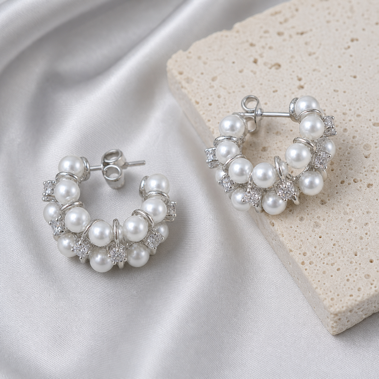 Crystal Pearl Hoop Earrings styled on silver silk and pale stone