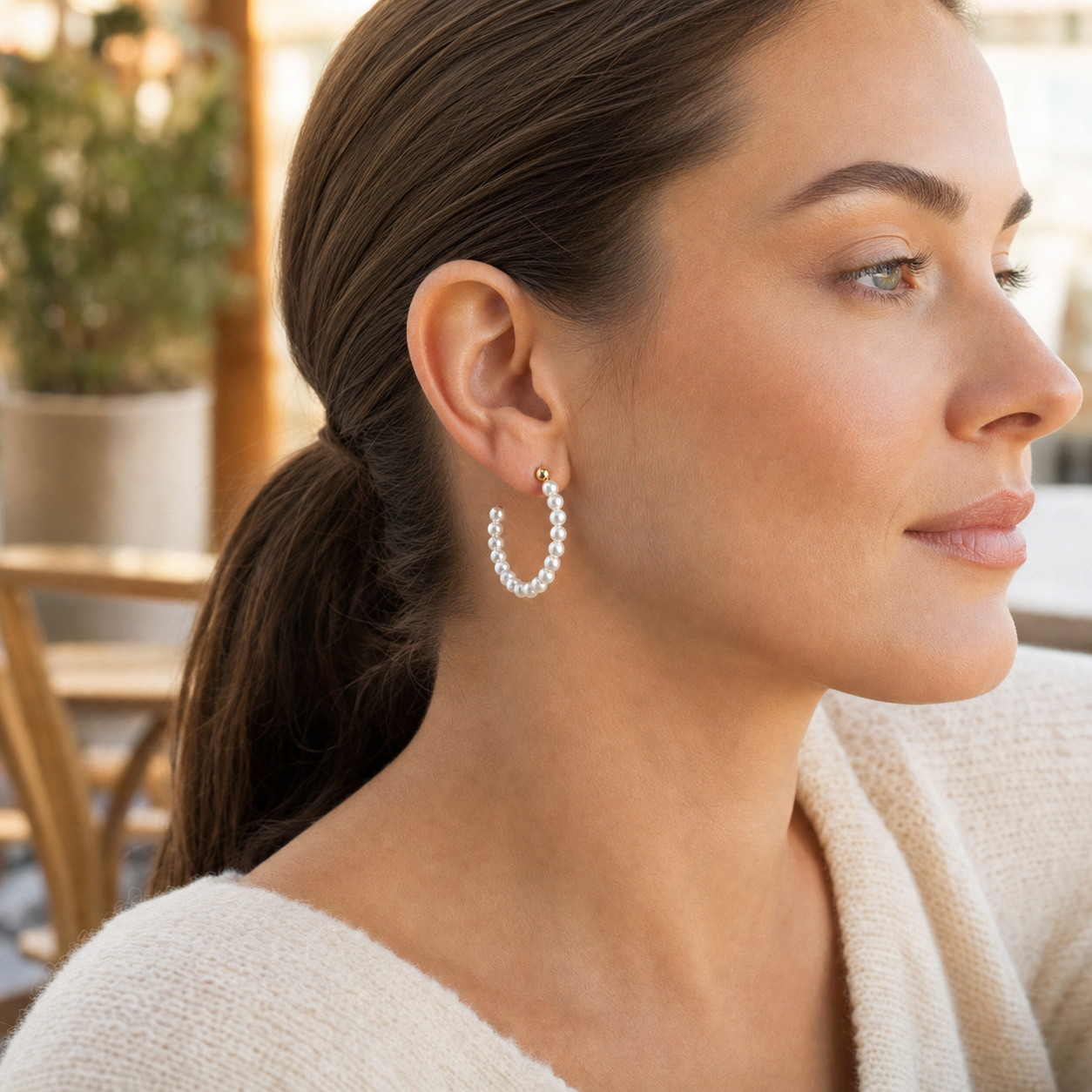 Model wearing gold-tone Pearl Hoop Earrings in warm daylight